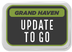 Sign with the text 'Grand Haven Update To Go' displayed in a rectangular format.